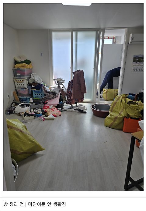 방, 미닫이문 앞에 쌓인 생활짐 (정리 전)